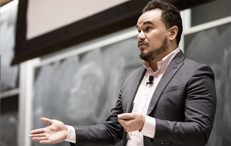Guadalupe Hayes-Mota teaching in a classroom in front of a chalk board