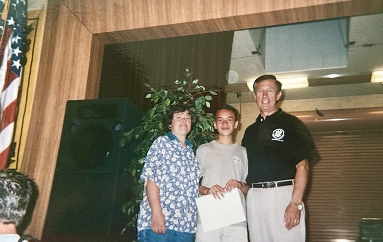 Guadalupe Hayes Mota as young teenager receiving certificate with two adults