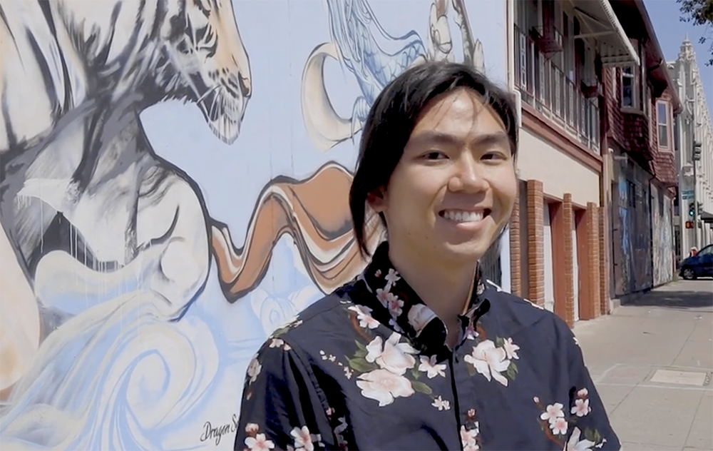 Lawton Young stands in front of mural in Oakland