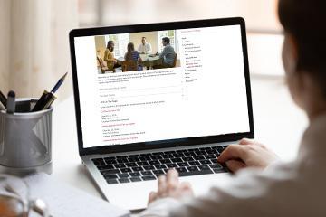 A pair of hands type on a laptop which shows the JST website 