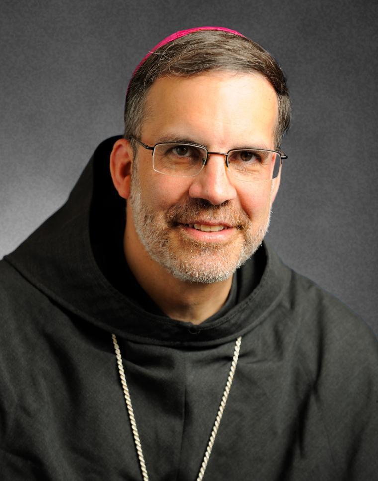 A person wearing religious attire with a cross necklace.