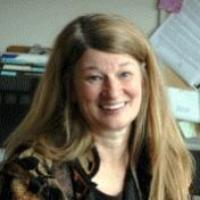 A woman smiling in an office environment.