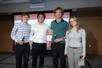 Four students standing on stage