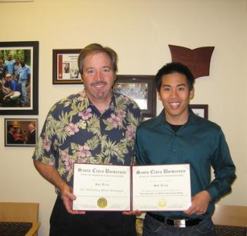 Two people holding a certificate titled 