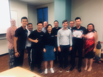 A group of people celebrates the '2019 1st Place Winner'.