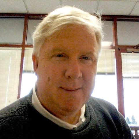 A person in an office with large windows behind them.