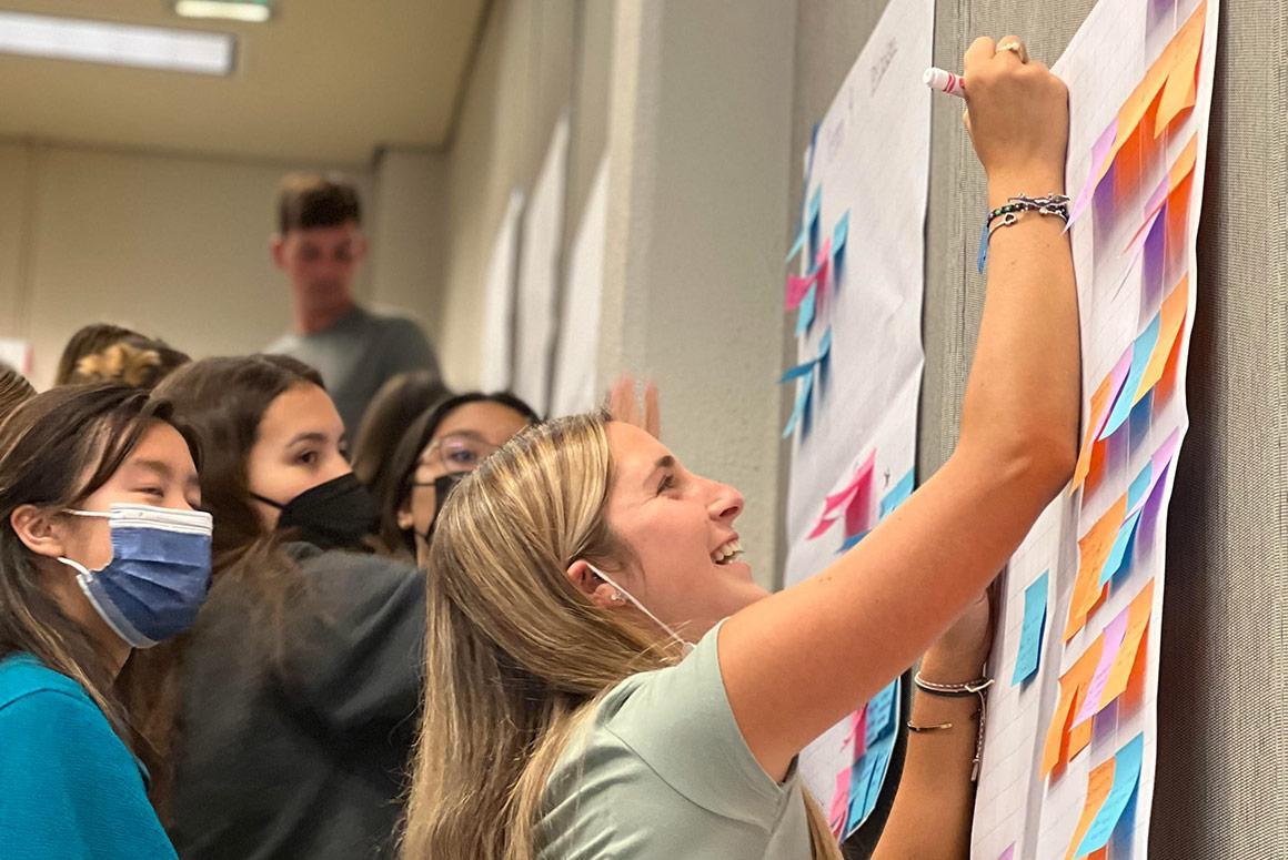 People brainstorming on a whiteboard at Ciocca Center's Idea Lab.