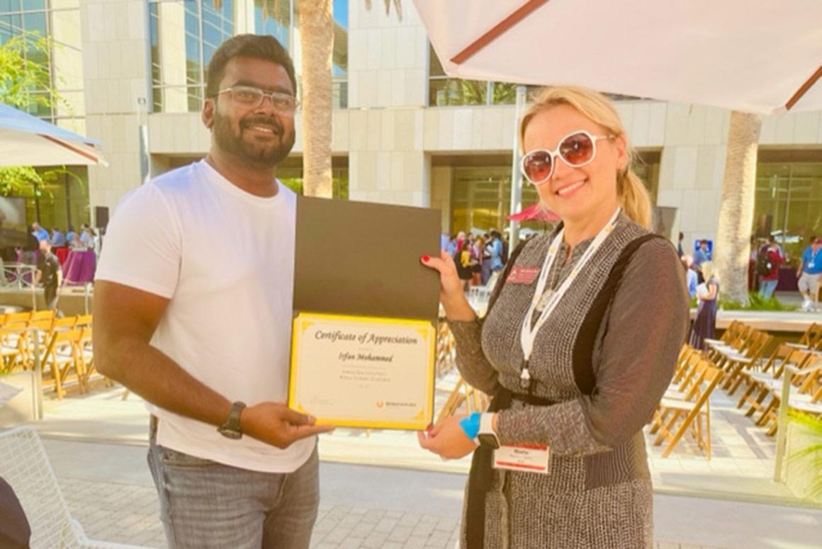 Two people outdoors holding a Ciocca Center plaque.