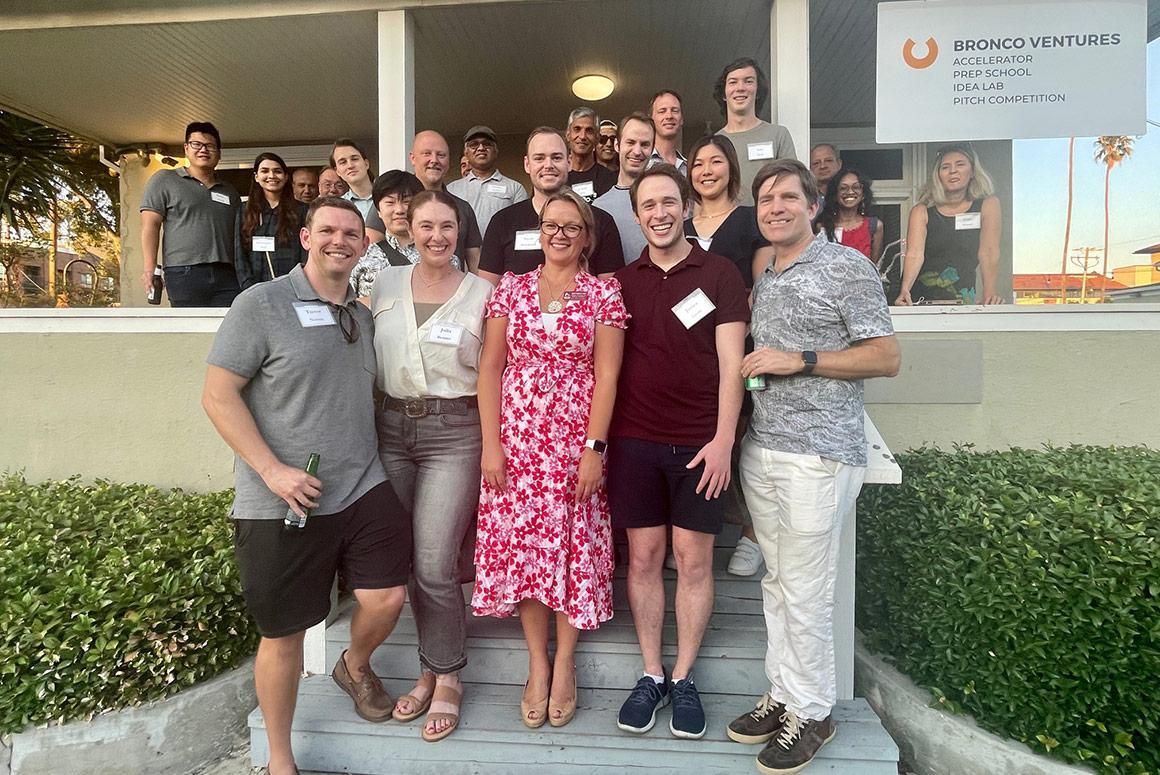 A group of people posing on steps at an event.