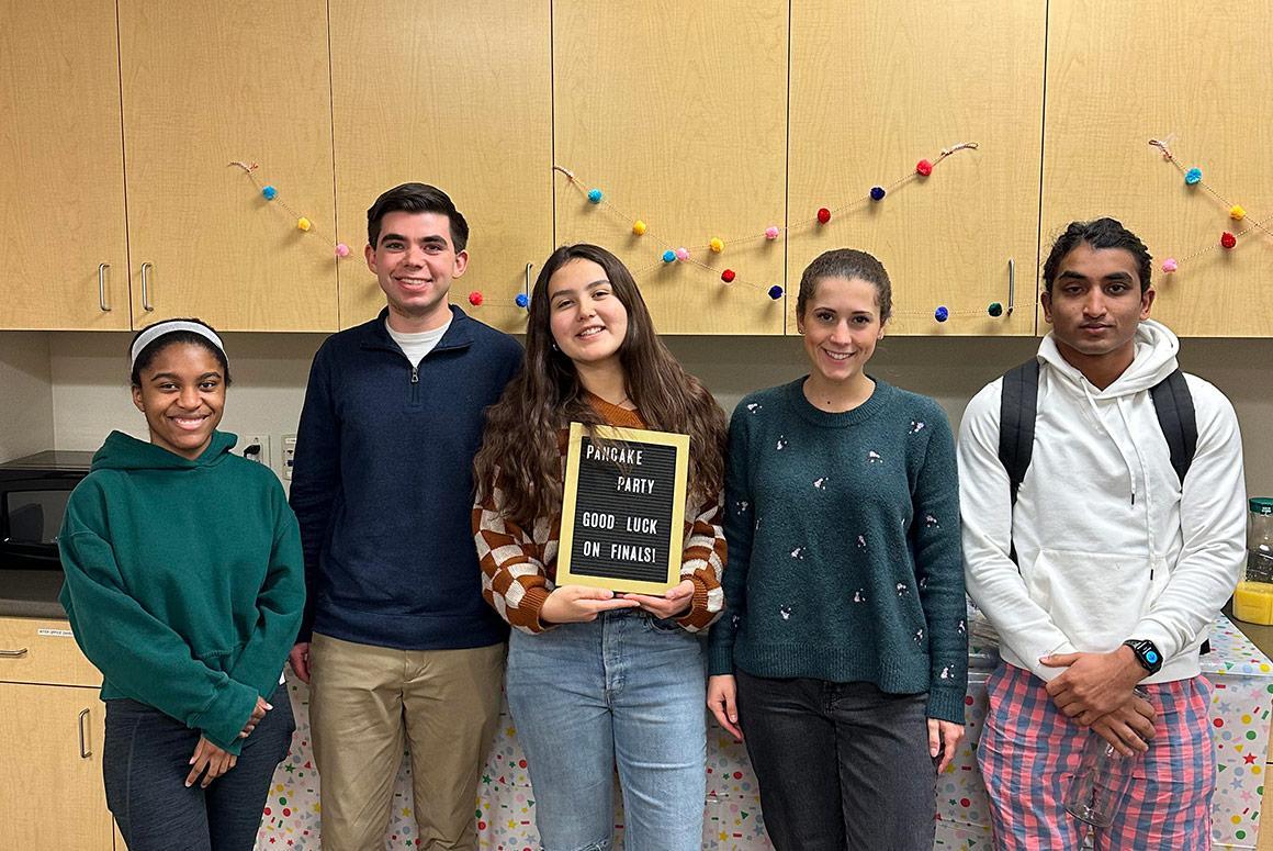Five people standing indoors, one holding a plaque, at Ciocca Center Pancake Breakfast.
