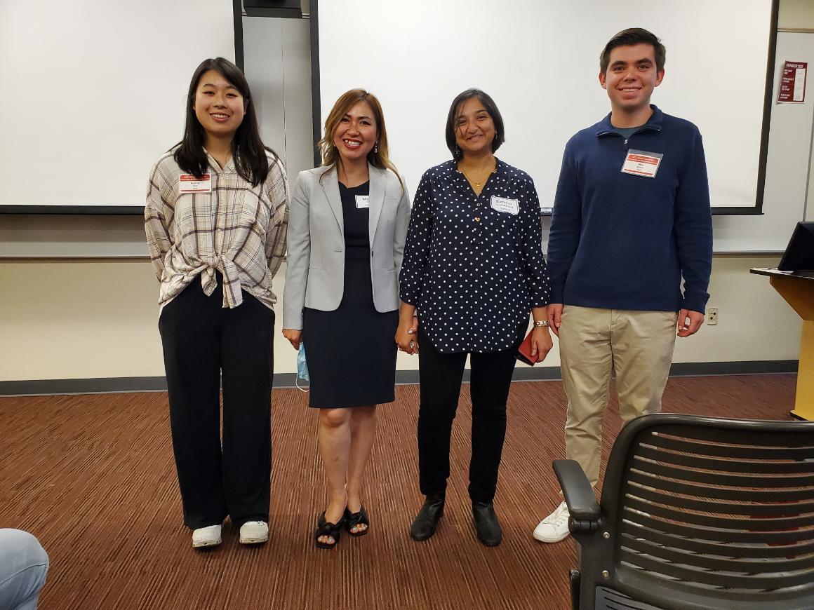 Four people standing in a room, some with nametags.