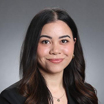 Woman with long hair and black blazer smiling