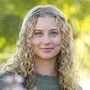 Woman smiling in green shirt outdoors