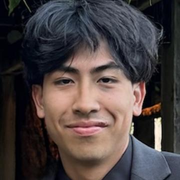 Man in black suit jacket smiling