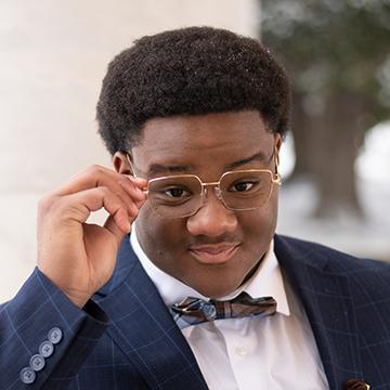 Man with glasses and bow tie smiling