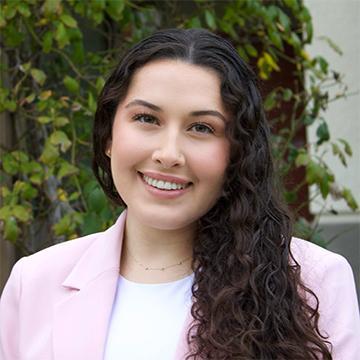 Woman in pink jacket and white shirt smiling