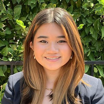 Woman in black blazer outdoors smiling