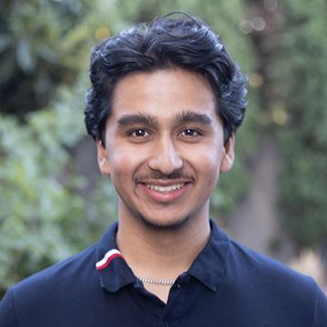 Man in gray polo smiling outdoors