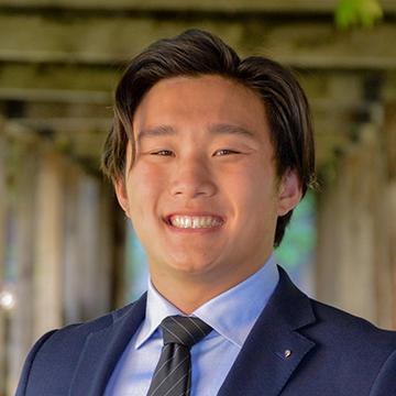 man smiling in suit and tie outdoors 