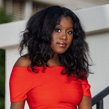 Woman in red dress outside smiling