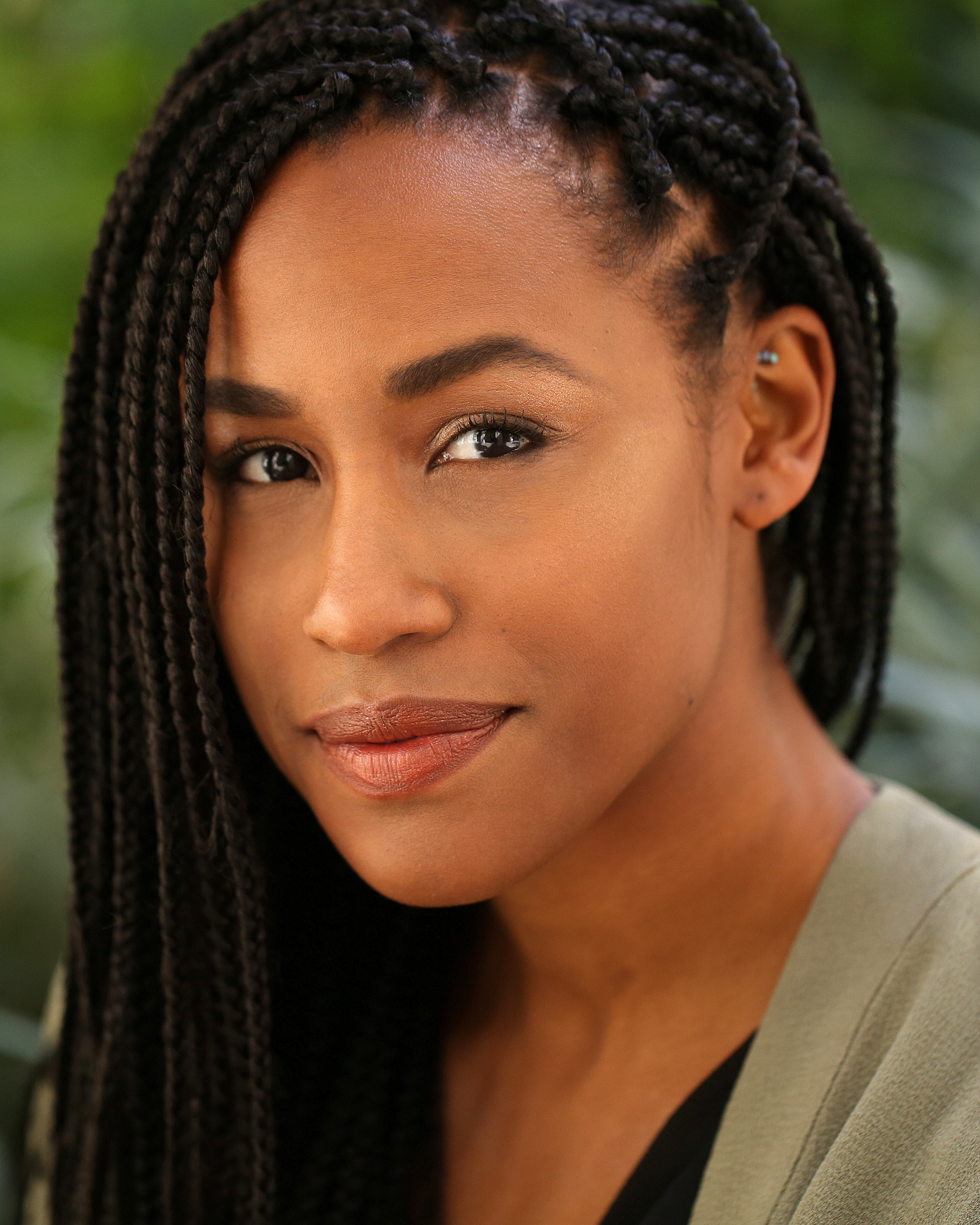 Portrait of Malarie Howard with greenery in the background.