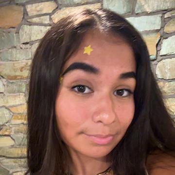 Woman smiling with brick wall in background