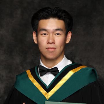 Man smiling in graduation robe