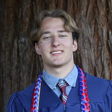 Man in graduation gown smiling