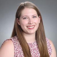 A person smiling against a plain background.