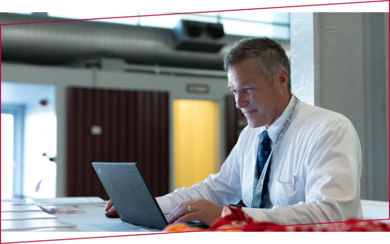 Man in a white shirt working on a laptop at Leavey Executive Center's Annual Symposium