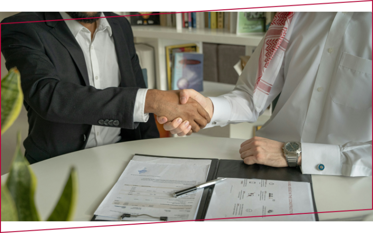 Shaking hands over a desk