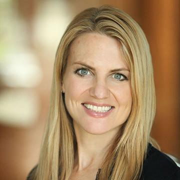 A woman smiling with a blurred background.
