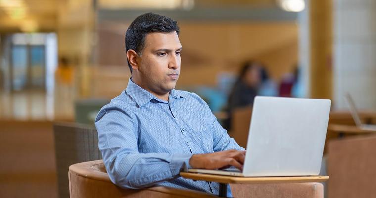 Leavey MBA candidate on laptop in Lucas Hall image link to article