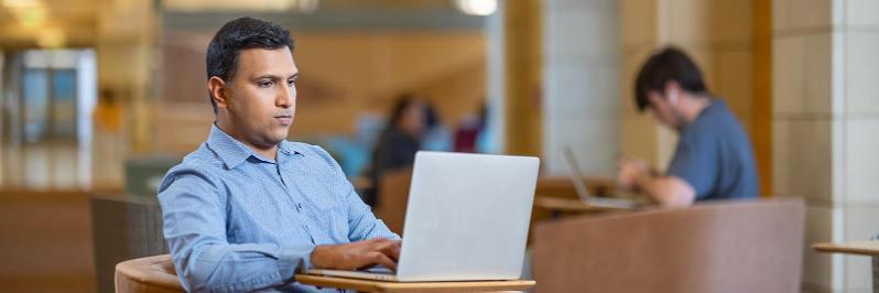 Leavey MBA candidate on laptop in Lucas Hall
