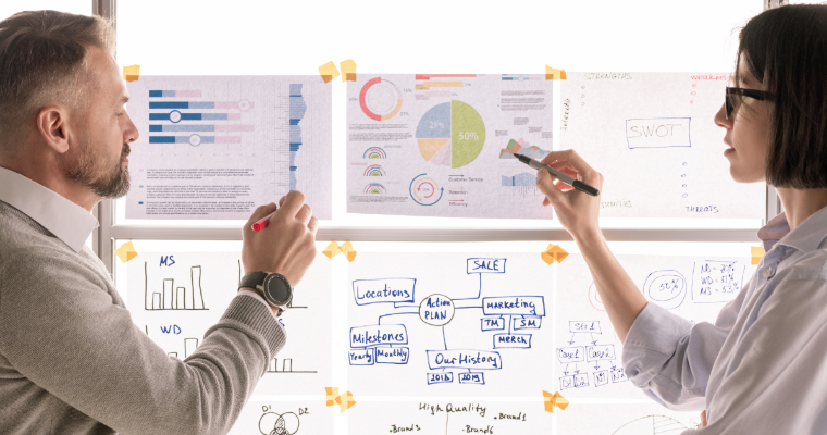 Business professionals discussing graphs taped to window image link to article