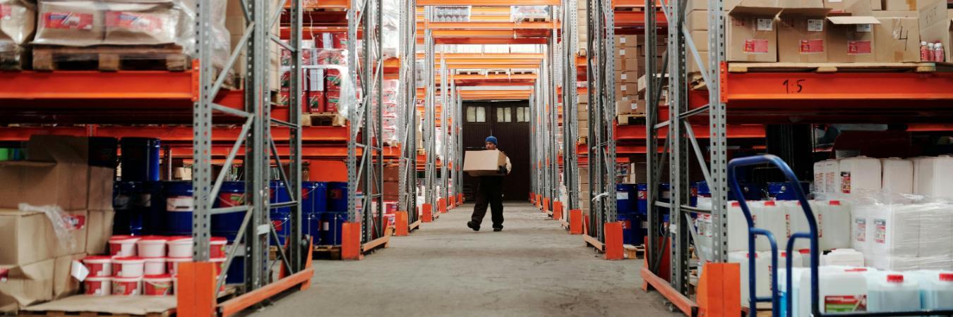 Employee carrying a box through a warehouse