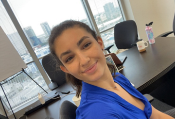 A person smiling in an office setting.