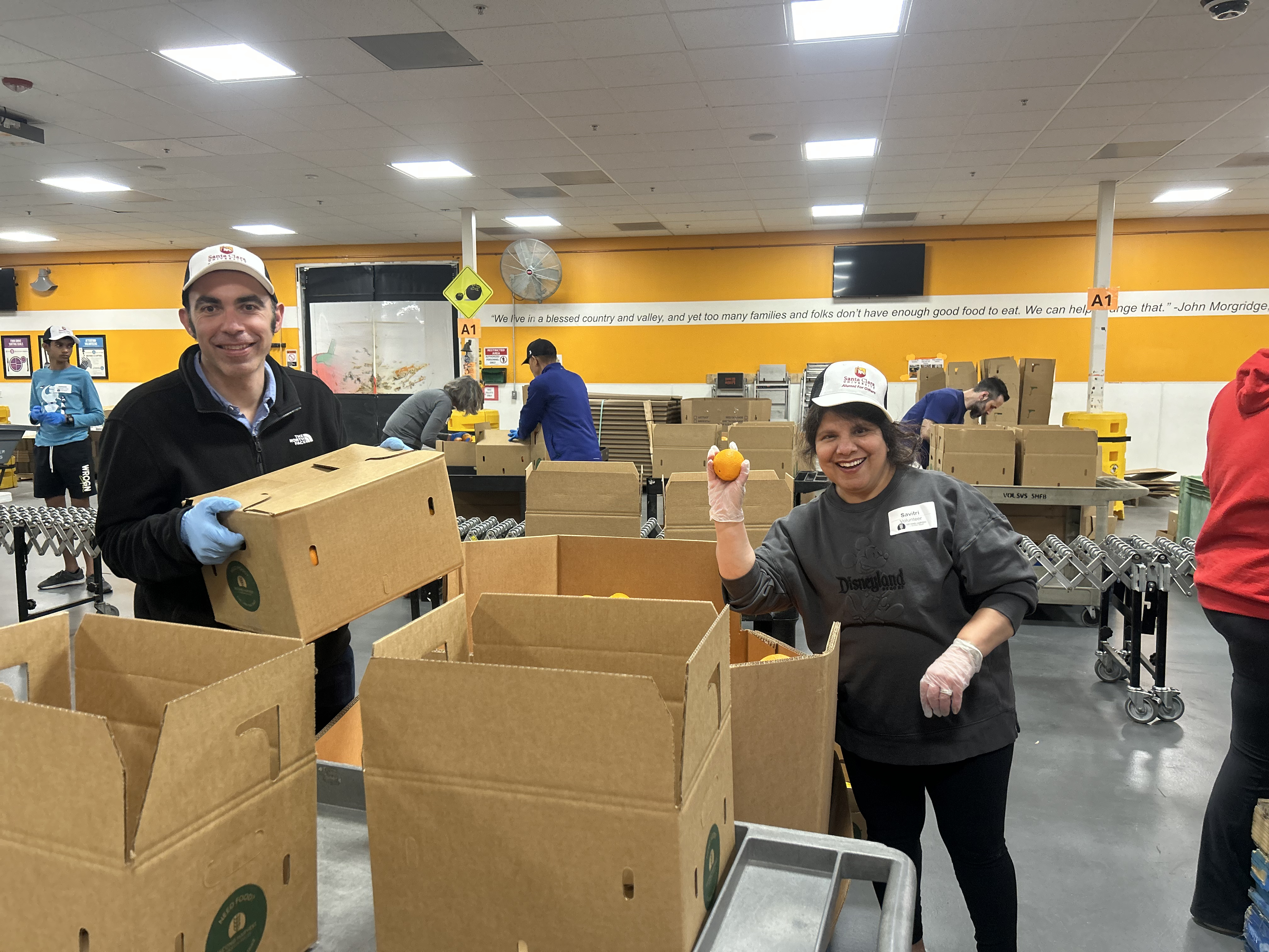 alumni helping passing out oranges