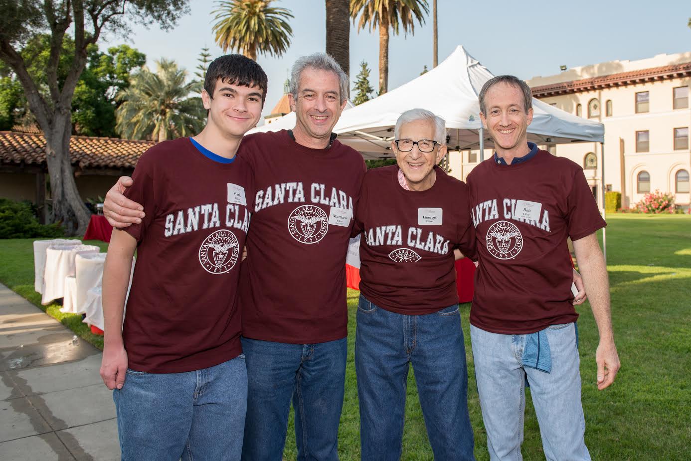 Four people in matching maroon shirts with 