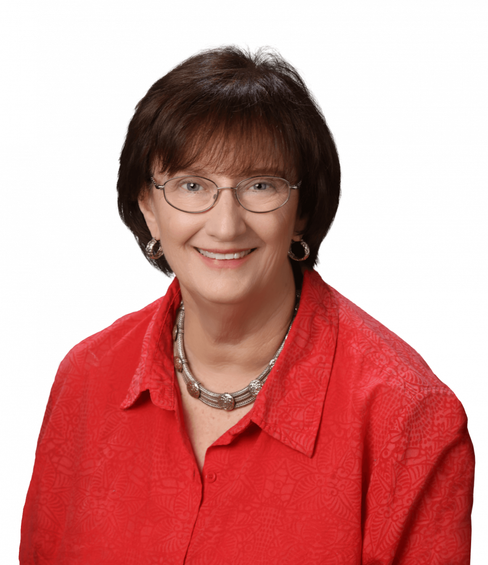 A person smiling, wearing glasses and a red shirt, with a black background.