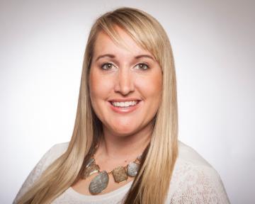 A smiling person in a professional headshot.