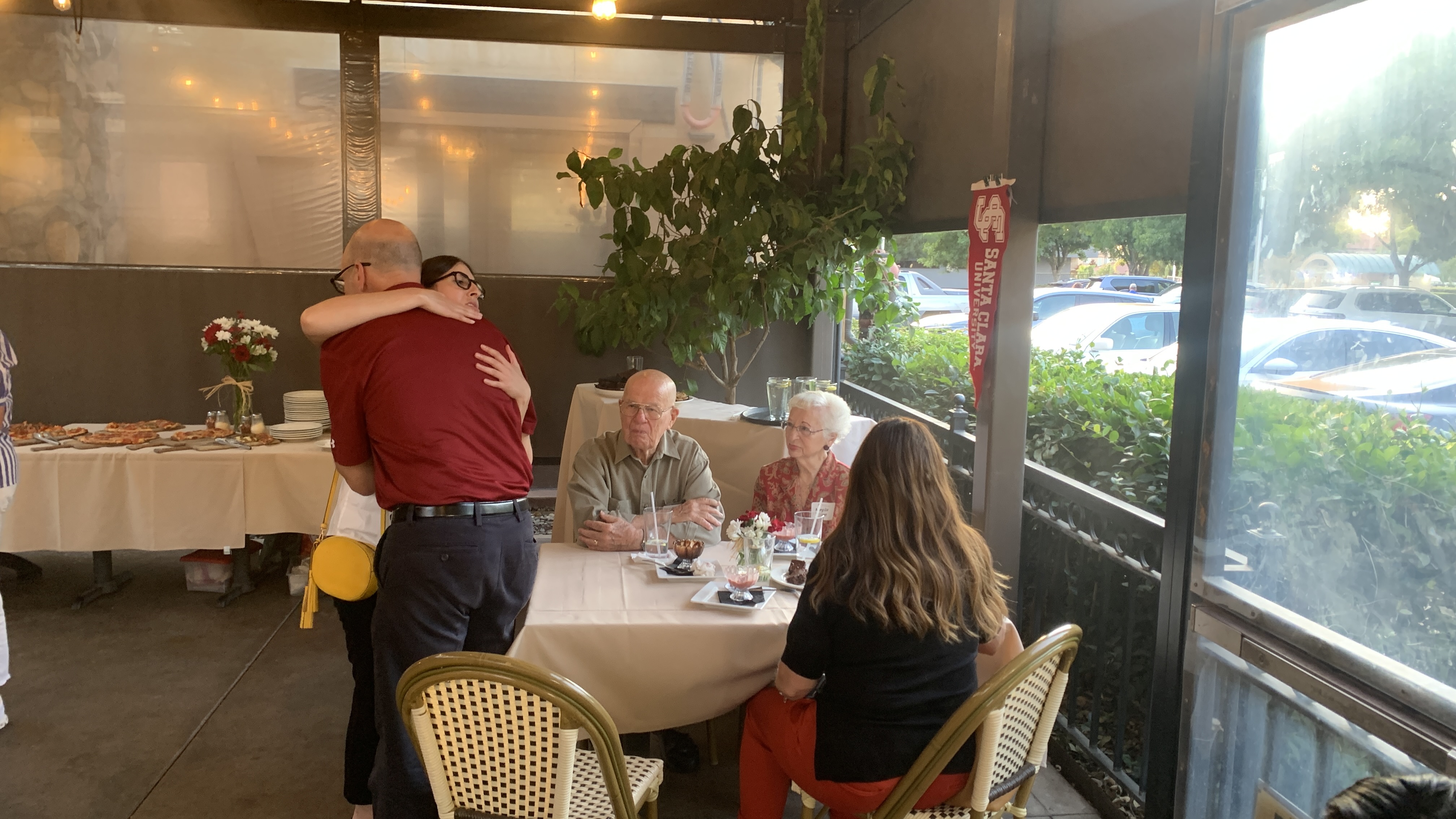 Alumni hug and sit for dinner at a Fresno event