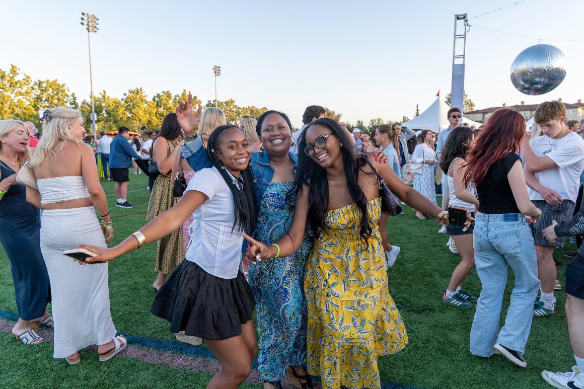 Three women smiling and dancing at Grad Bash 2025