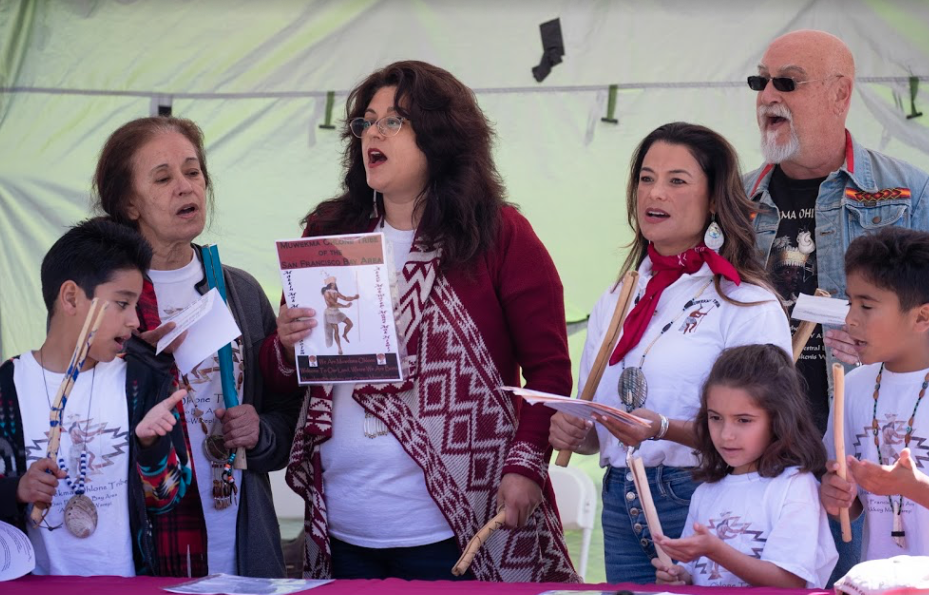 A group of people at the Native Alumni Grand Reunion holding a framed certificate.