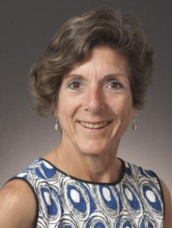 Alt text: Woman in blue and white patterned dress smiling, titled 'Angela Robbiano - HOF Committee'.