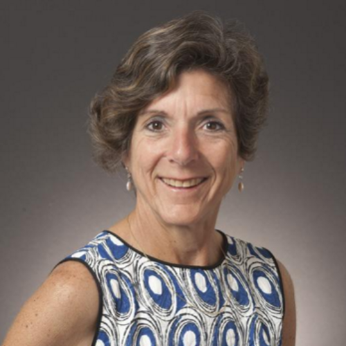 Alt text: Woman in blue and white patterned dress smiling, titled 'Angela Robbiano - HOF Committee'.