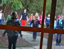 People standing in a circle during an outdoor retreat activity.