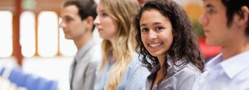 A group of people smiling and socializing outdoors.