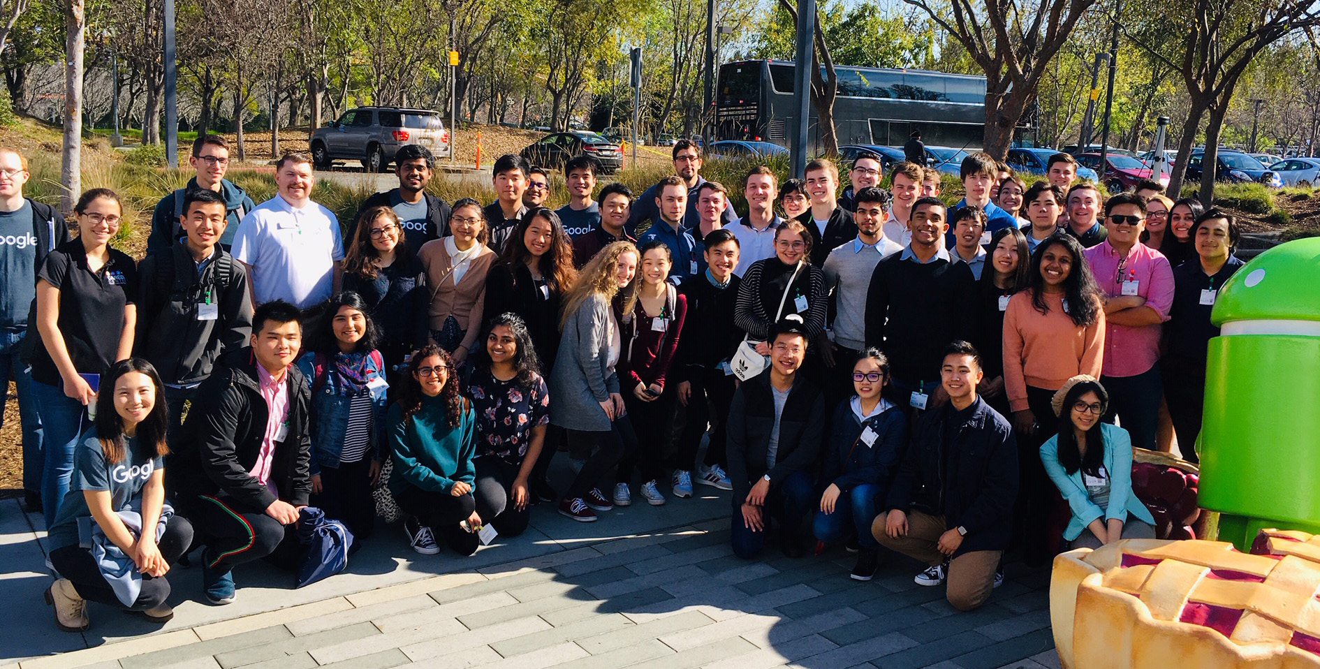 A large group of people posing outdoors during a trek.