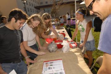 Students gathered around a table with various items at Santa Clara University.